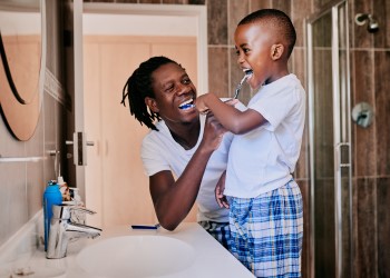 father and son brushing teeth