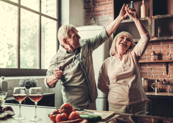 older couple with veneers dancing in kitchen