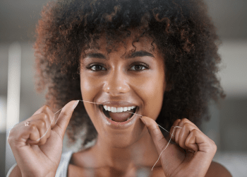 woman flossing teeth with veneers
