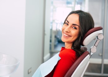 woman with veneers smiling in dental chair